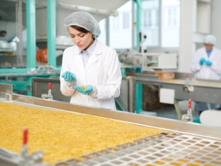 Woman checking pasta in a factory