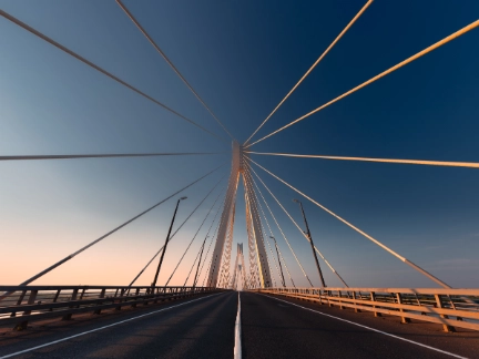 A suspension bridge with an empty road at sunset